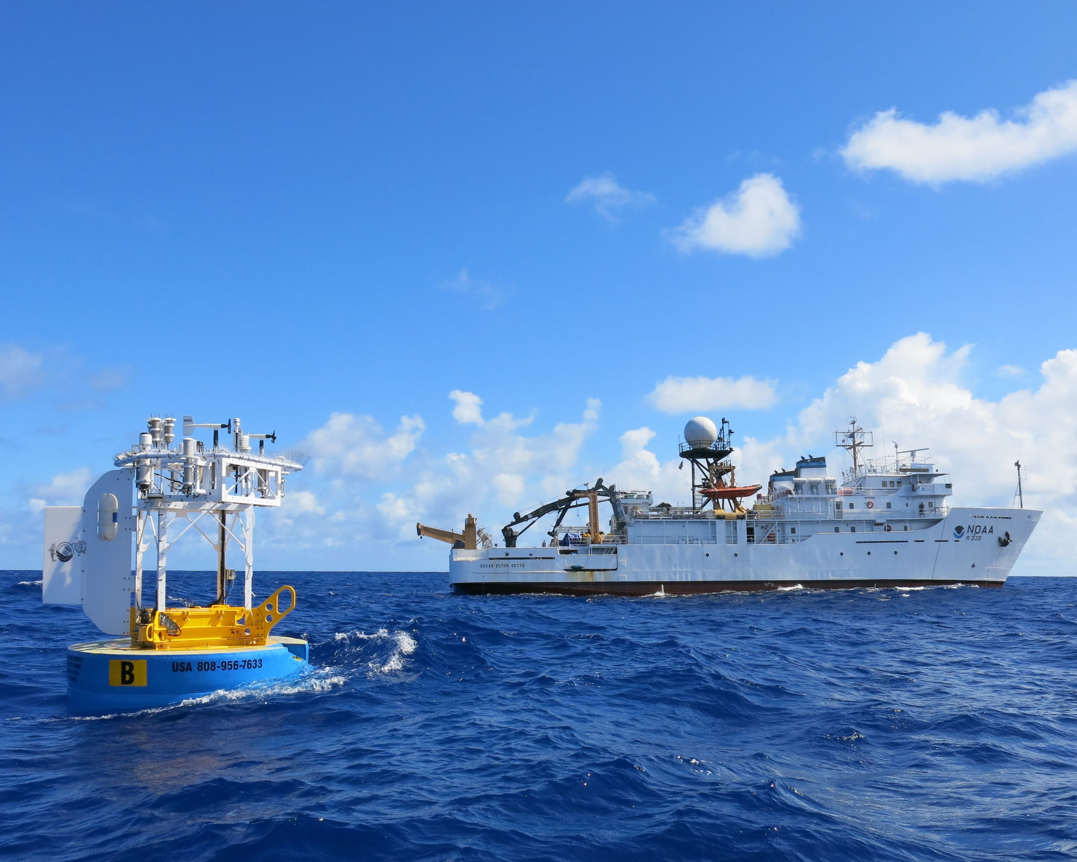 The WHOI Hawaii Ocean Time-series Station (WHOTS)-19 buoy after deployment, with NOAA Ship Oscar Elton Sette in the background in June 2023